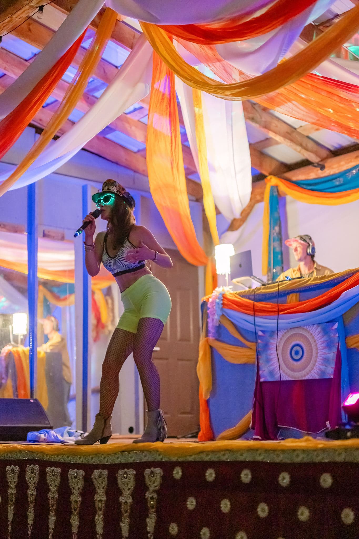 Lara Brightside singing on stage during a colourful live performance.