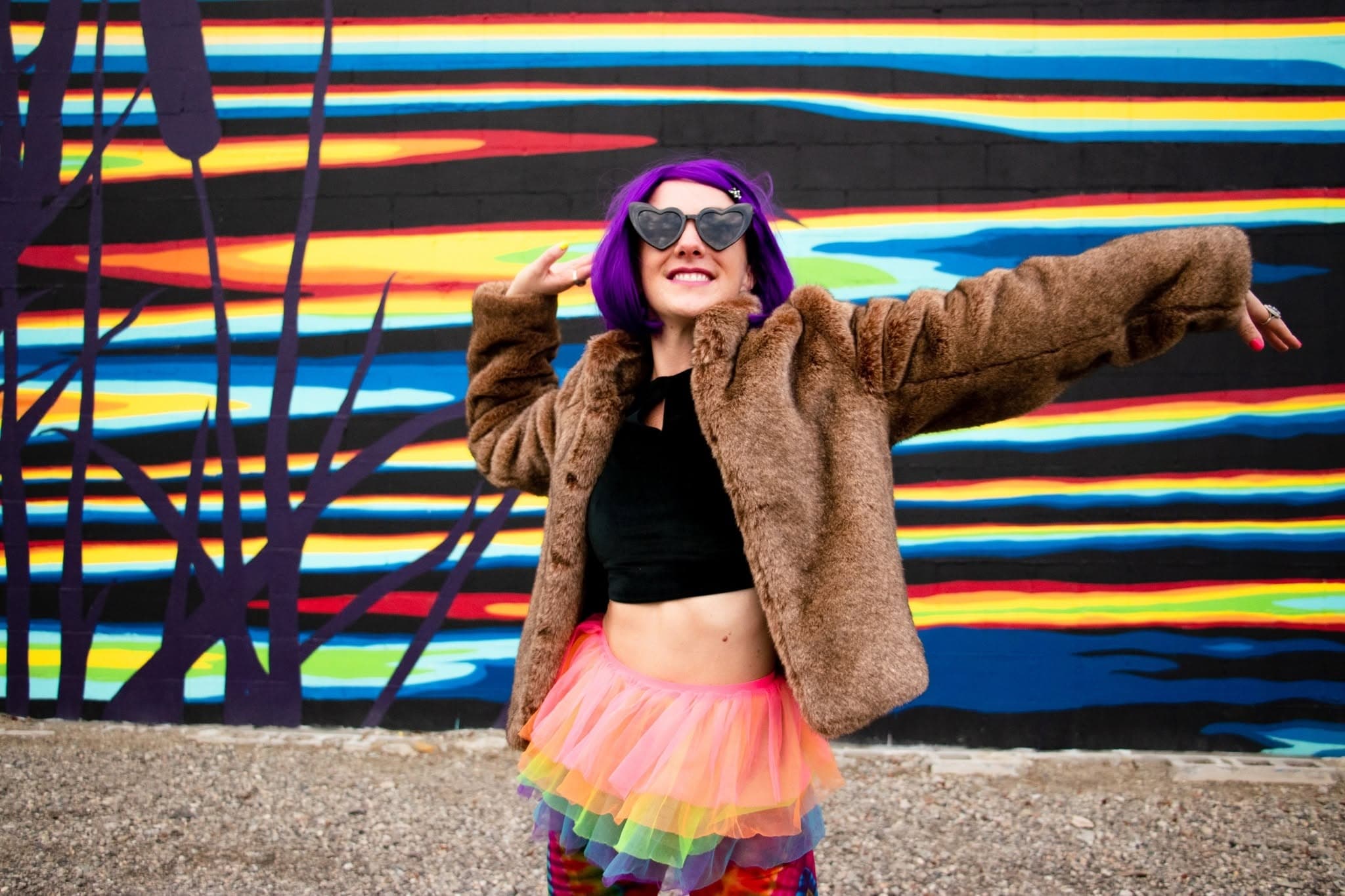 Lara Brightside smiling in heart-shaped sunglasses and colourful festival-inspired fashion.