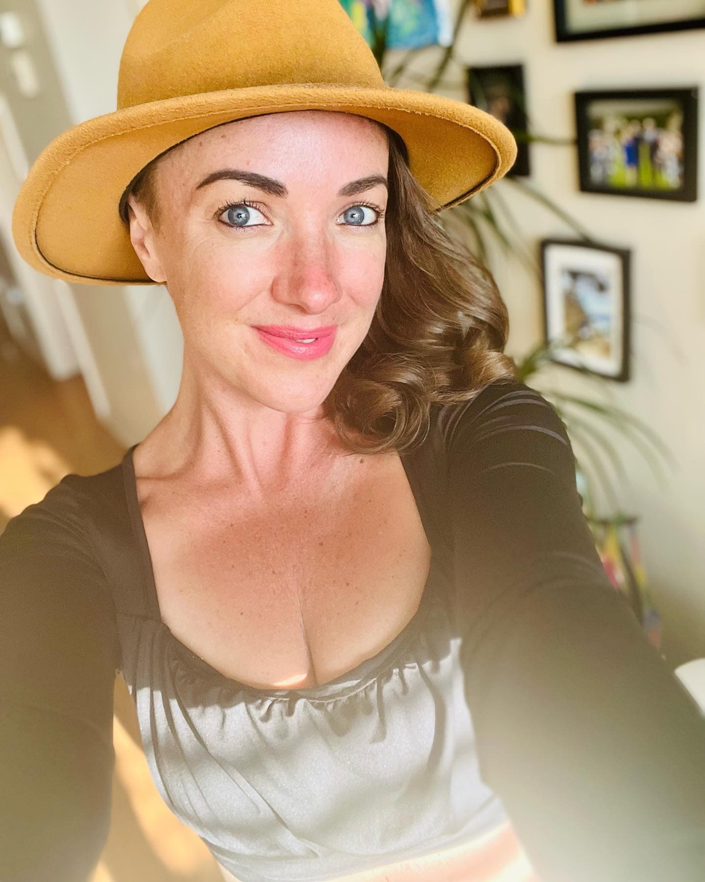Lara Brightside smiling outdoors in a tan hat.